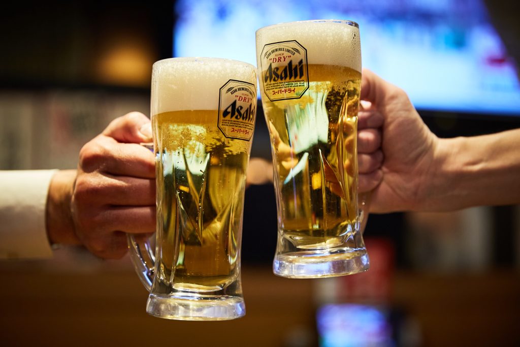池袋でコスパ抜群の居酒屋チェーン「三代目鳥メロ」アサヒスーパードライ生ビールジョッキを持って乾杯している男性2人の画像